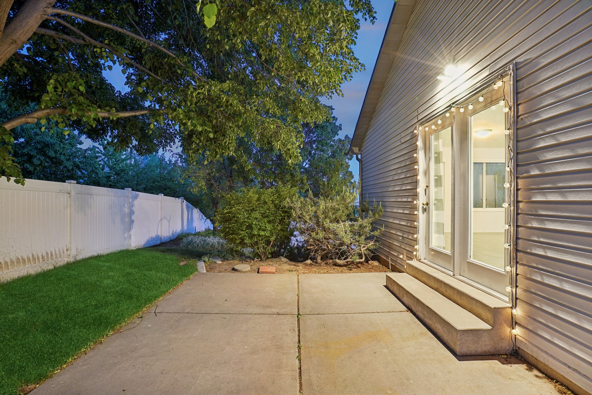 Outdoor patio featuring a concrete surface, direct access via double glass doors, and a manicured lawn area
