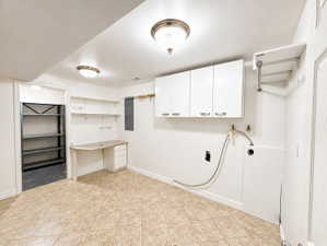 Laundry area with electric panel, hookup for a washing machine, and cabinet space