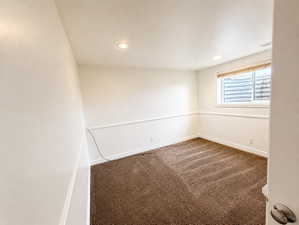 Spare room with dark carpet and recessed lighting