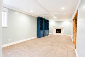 Unfurnished living room with light carpet, built in features, a fireplace, and recessed lighting