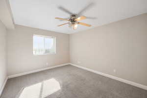 Spare room with light colored carpet and a ceiling fan