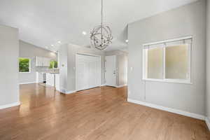 Entryway featuring hanging lights, light wood-style flooring, and lofted ceiling