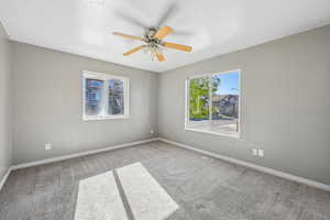 Spare room with light carpet and a ceiling fan