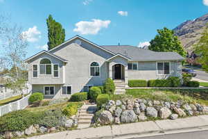 Single story home with stucco siding, a chimney, and a shingled roof