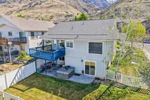 Back of house with a patio, a mountain view, a shingled roof, and a fenced backyard