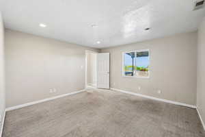Carpeted empty room with recessed lighting