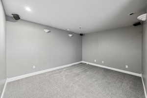 Empty room featuring light colored carpet and baseboards