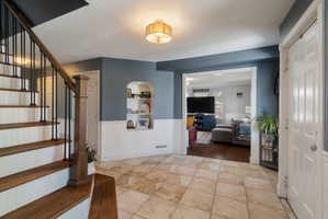 Entryway featuring large format tile flooring and a contrasting wainscoting