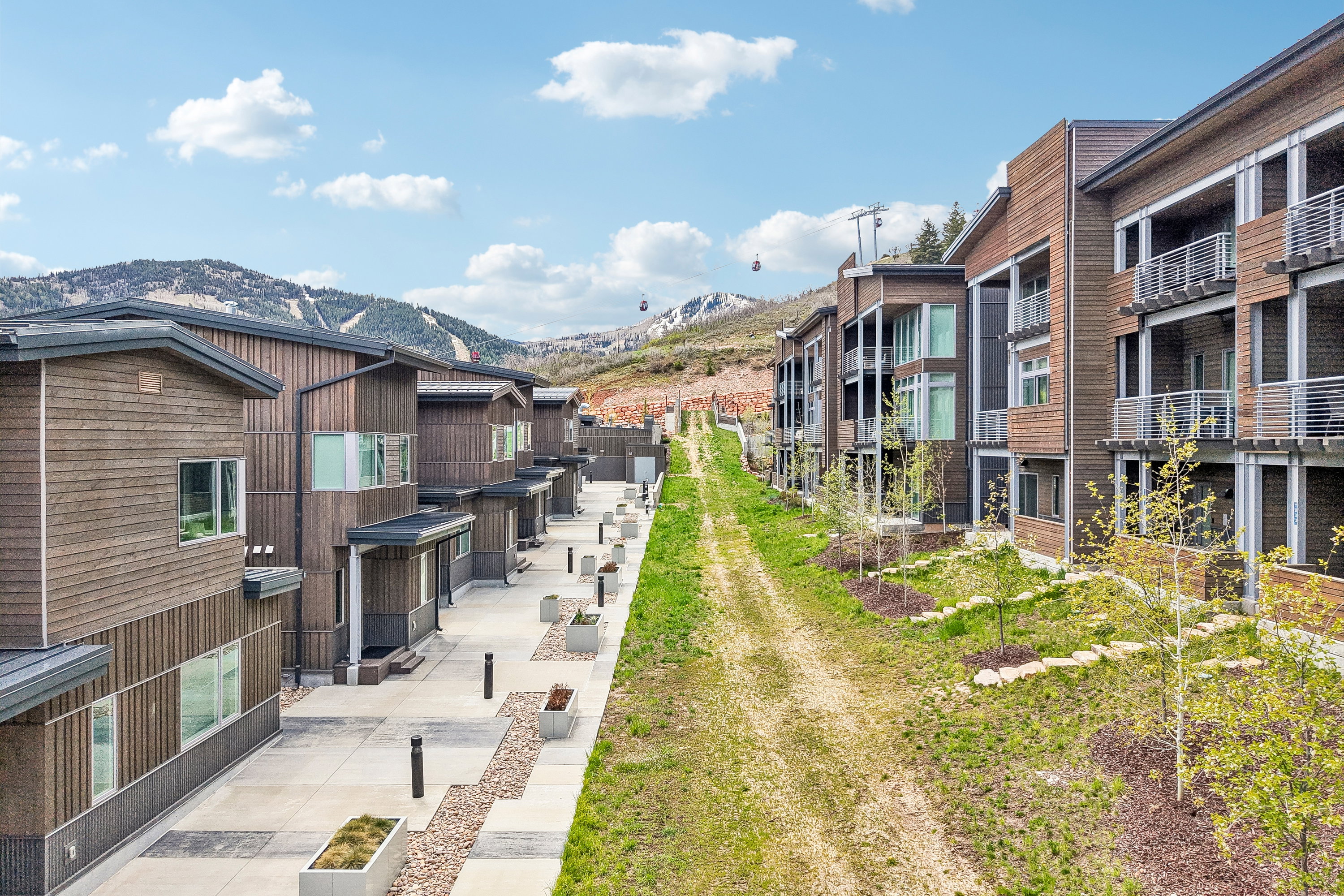 Modern multi-story residences featuring wood paneling, extensive window placements, and private balconies with horizontal railings