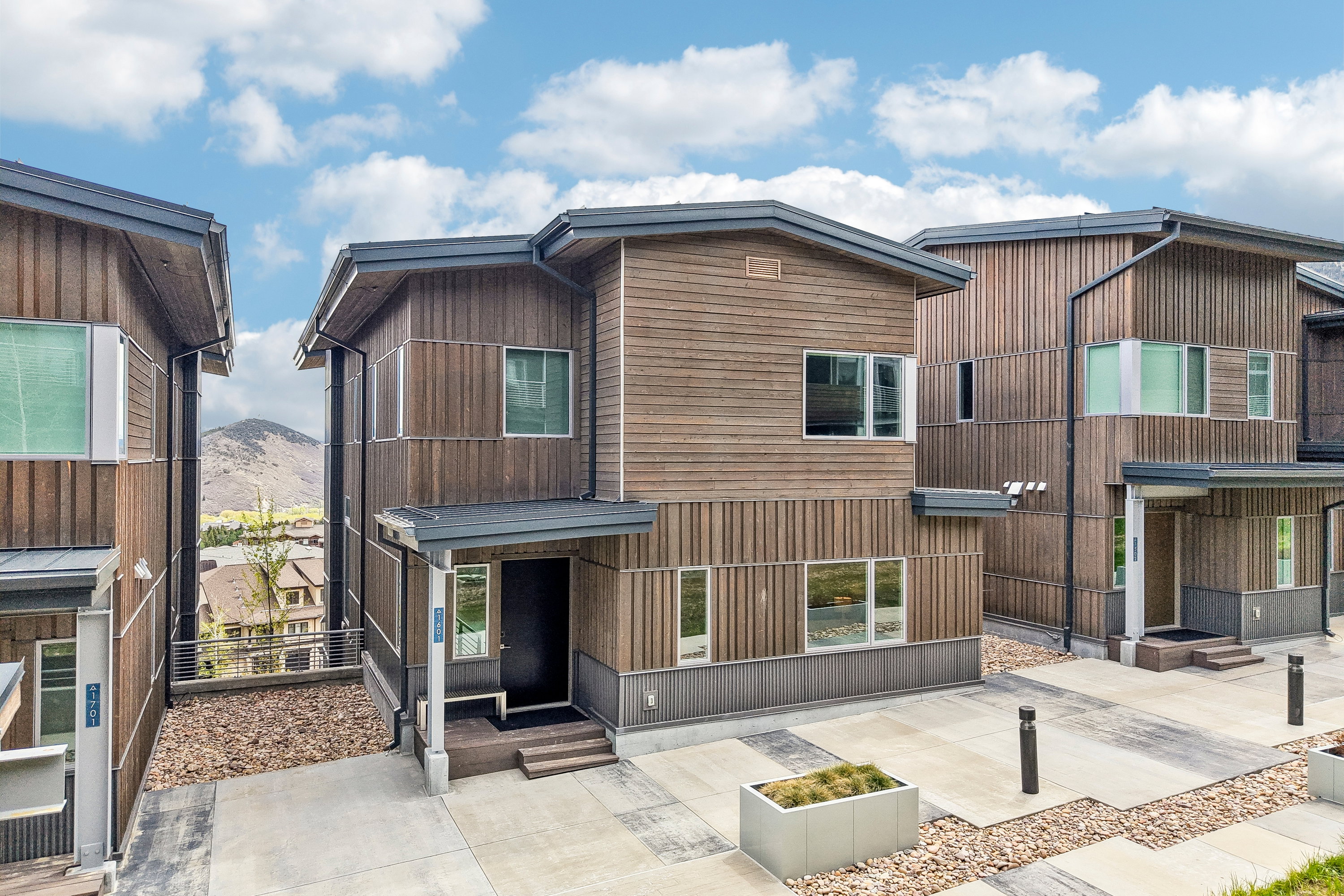 Modern multi-level residence featuring wood siding and a covered entry