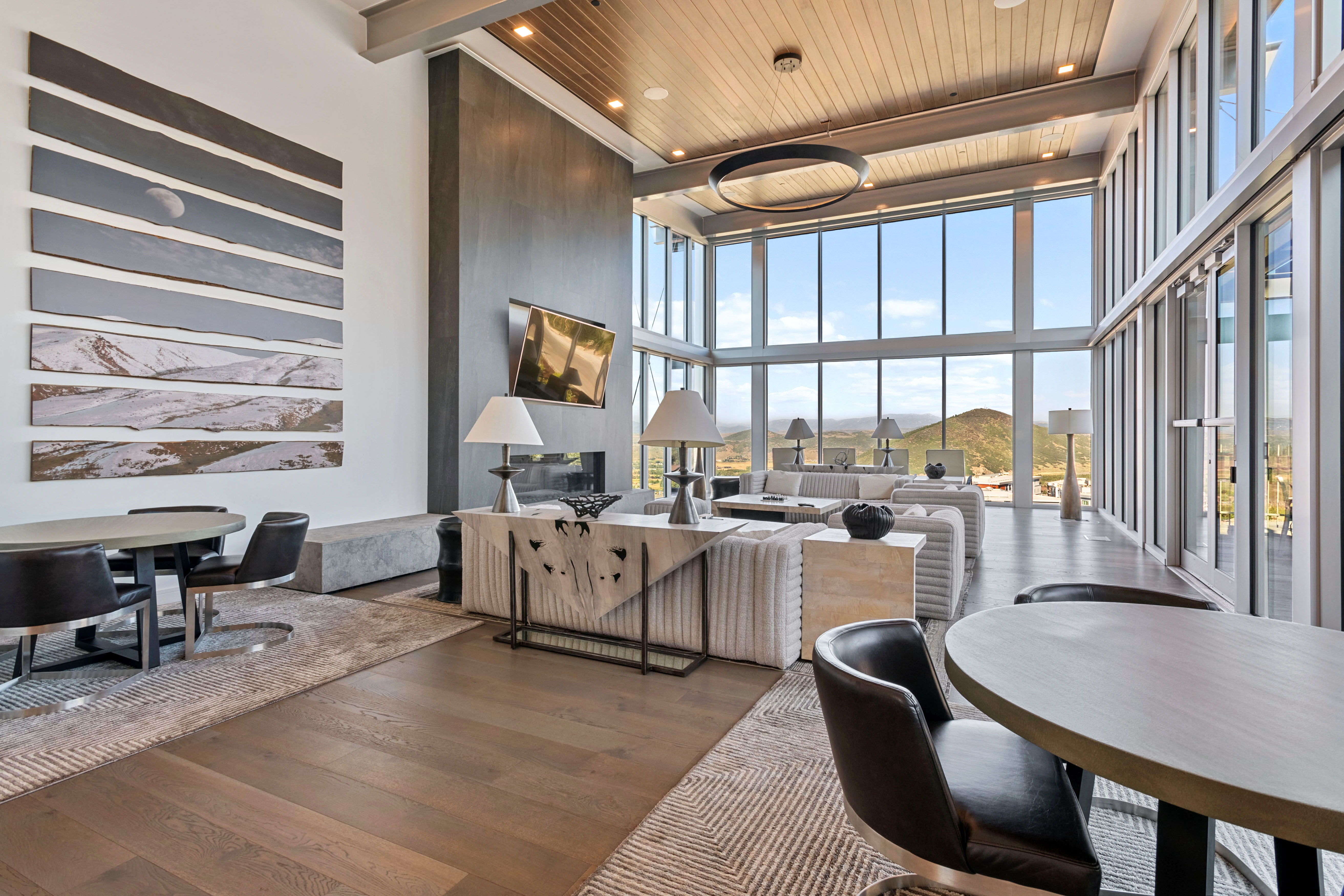 Great room featuring floor-to-ceiling windows, wood-finish flooring, and a contemporary fireplace