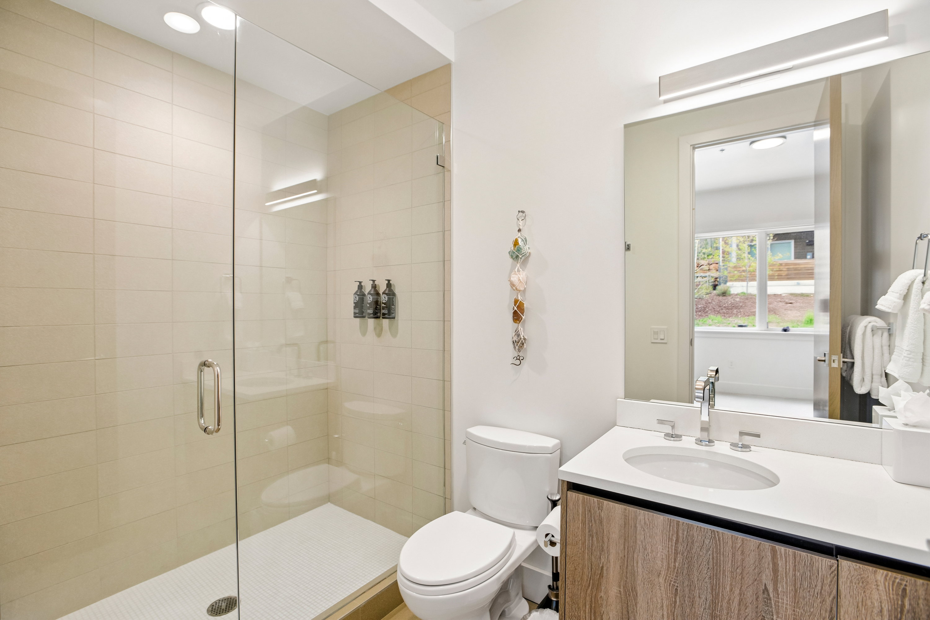 Bathroom featuring a glass-enclosed shower with tiled walls and a built-in shelf