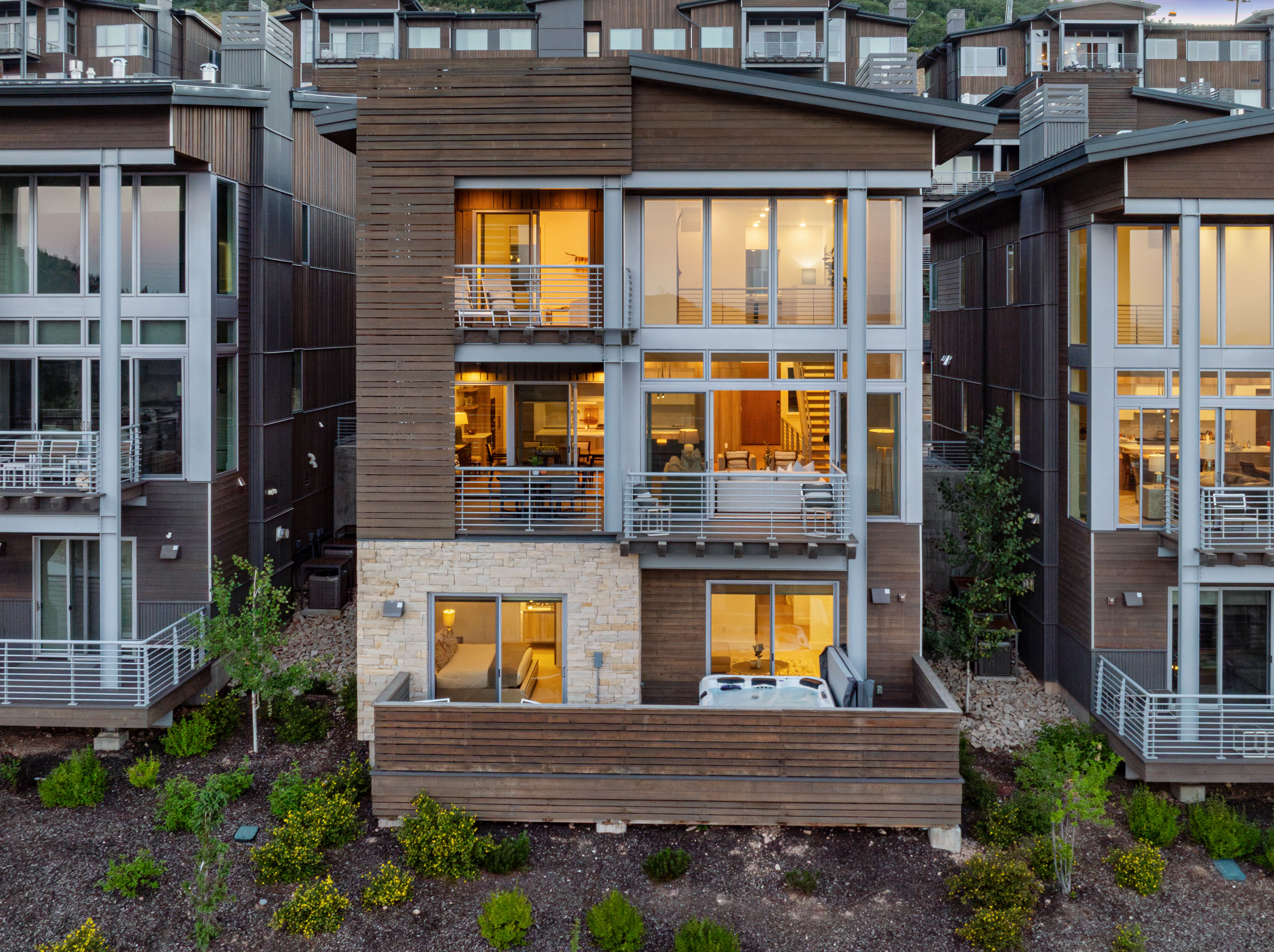 Modern multi-story facade featuring wood siding and stone accents