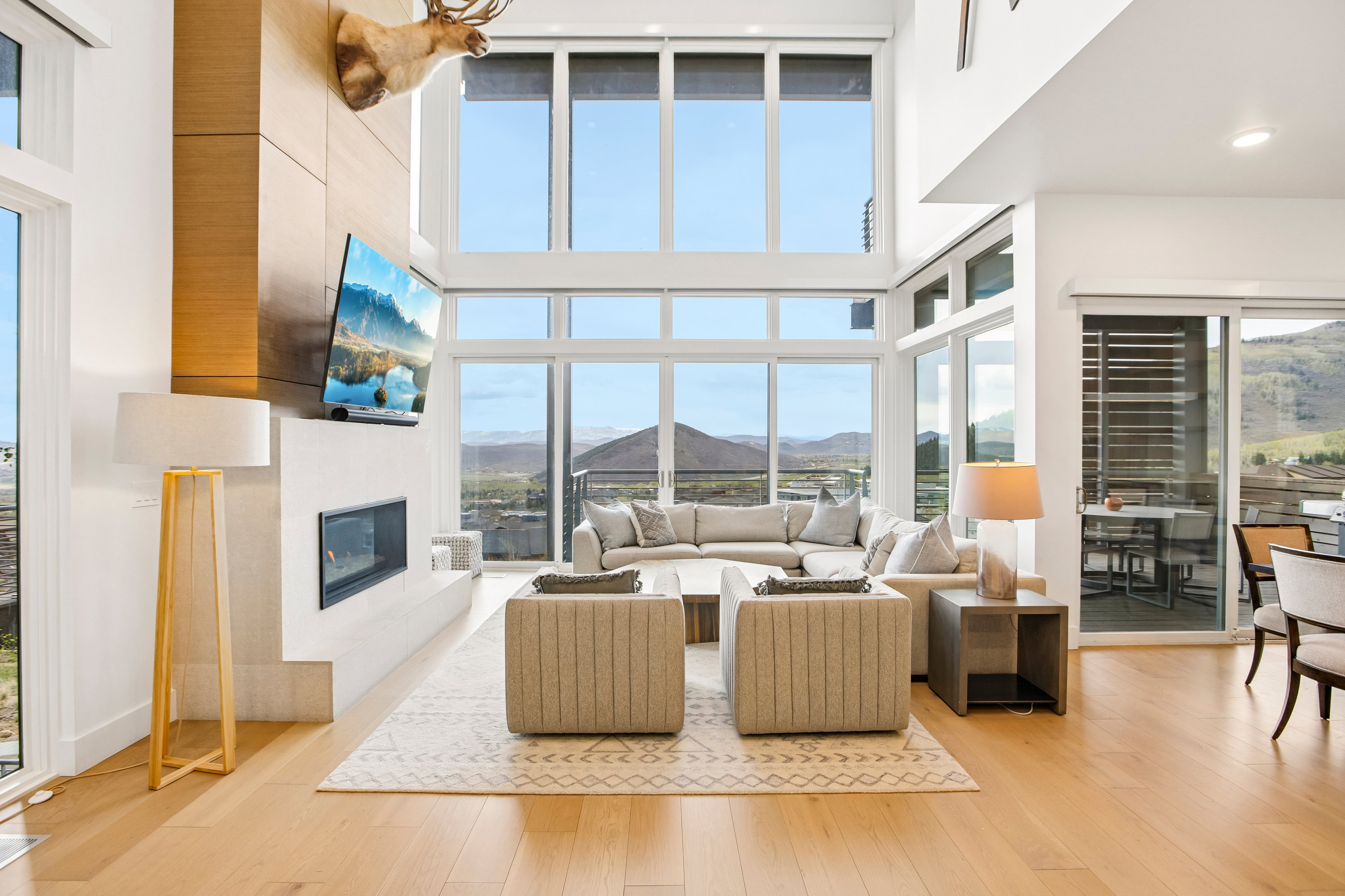 Spacious open-concept living area featuring wood-finish flooring and a two-story wall of windows
