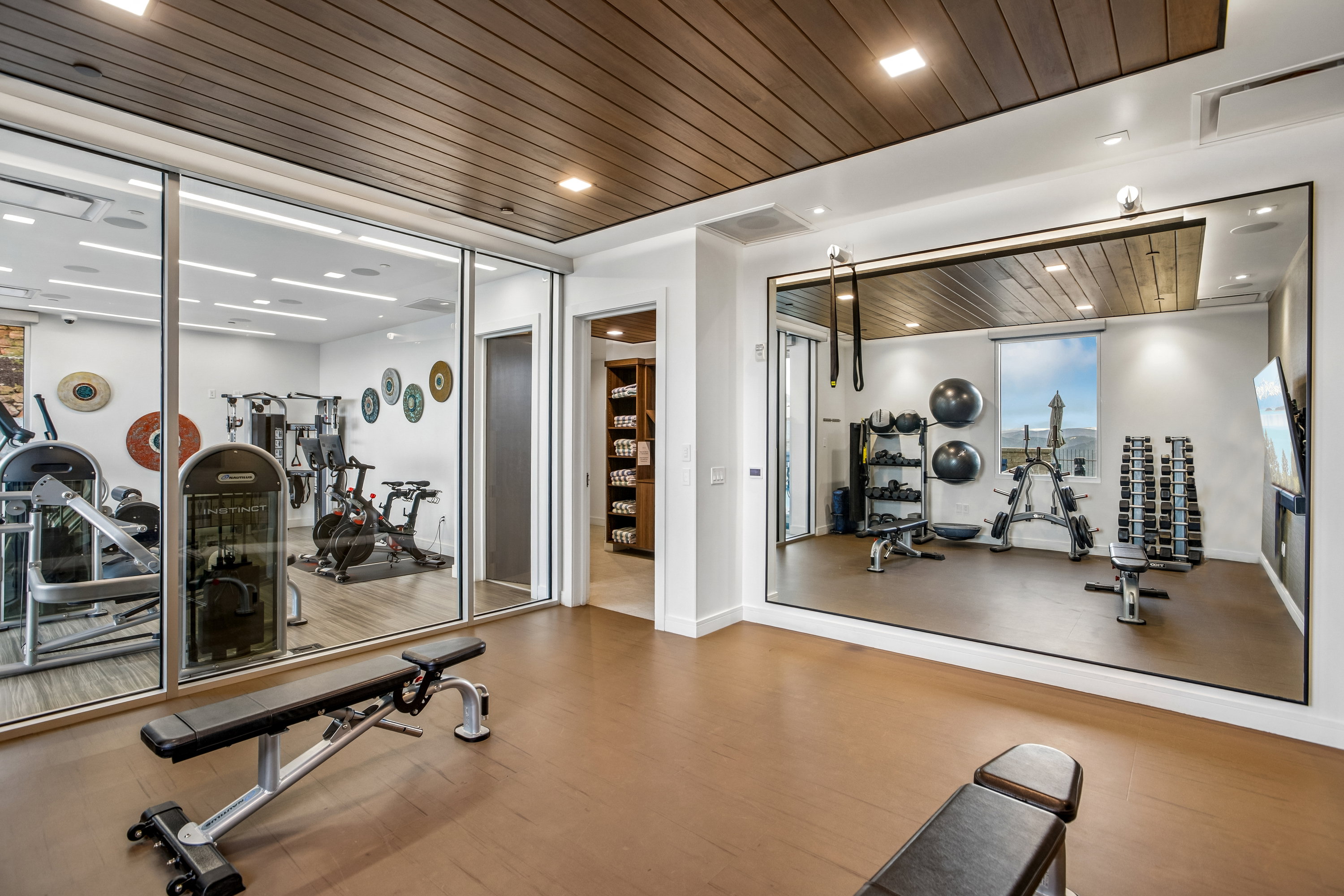 Dedicated fitness room featuring wood-finish flooring and a slatted wood ceiling