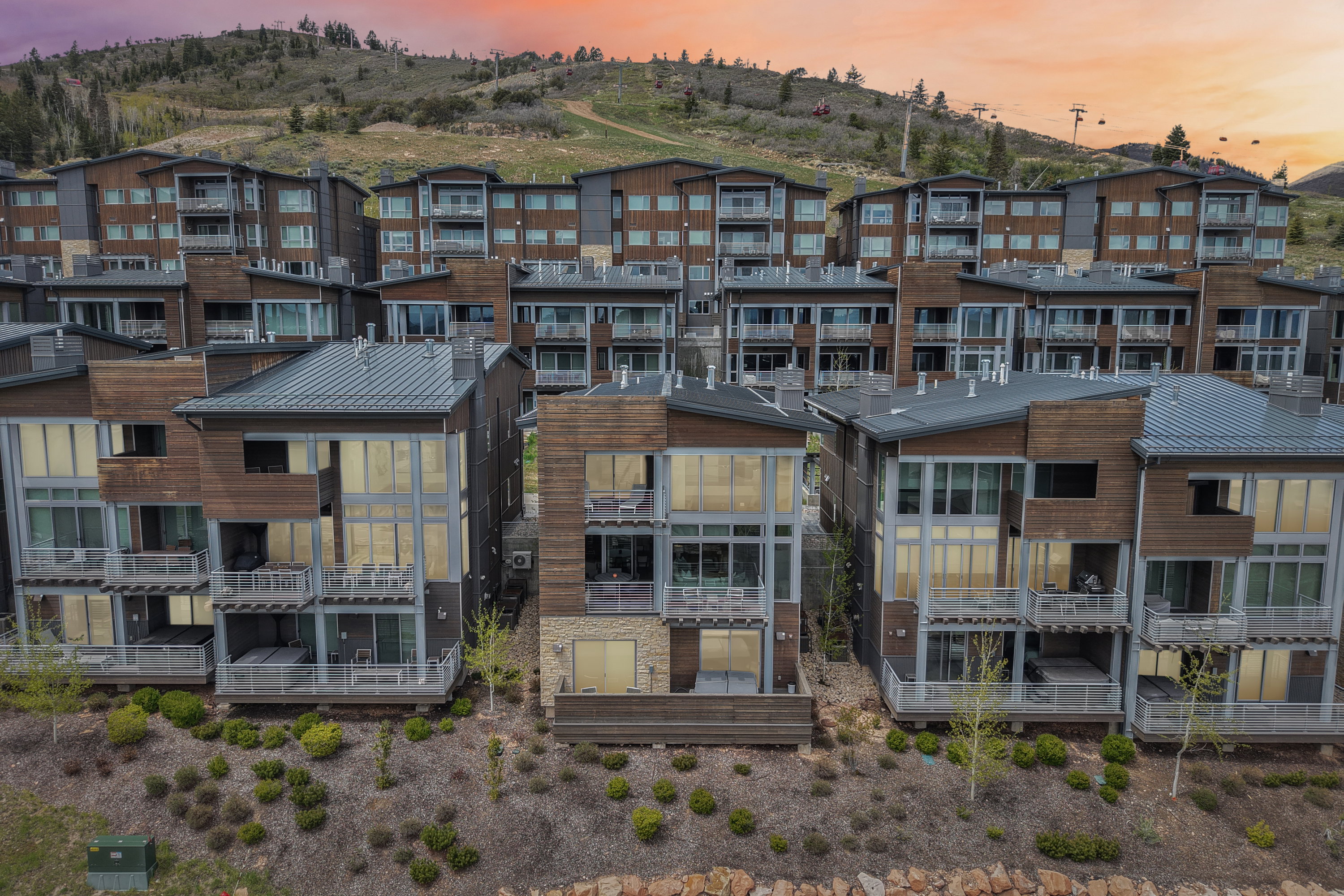 Multi-level contemporary residences featuring extensive glazing, private balconies, and stone and wood-panel accents