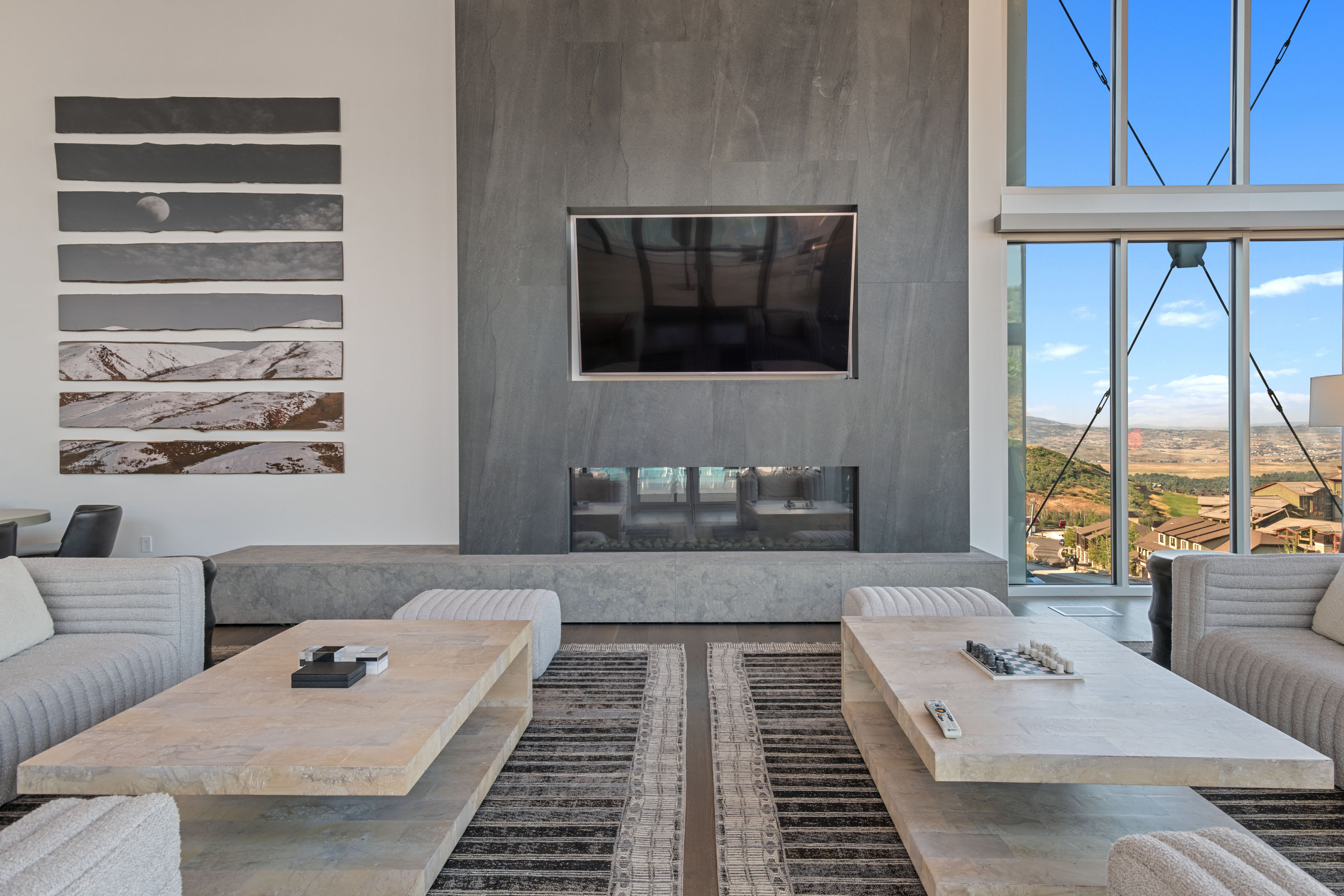 Living area with a stone-clad fireplace and integrated television, featuring a linear gas fireplace