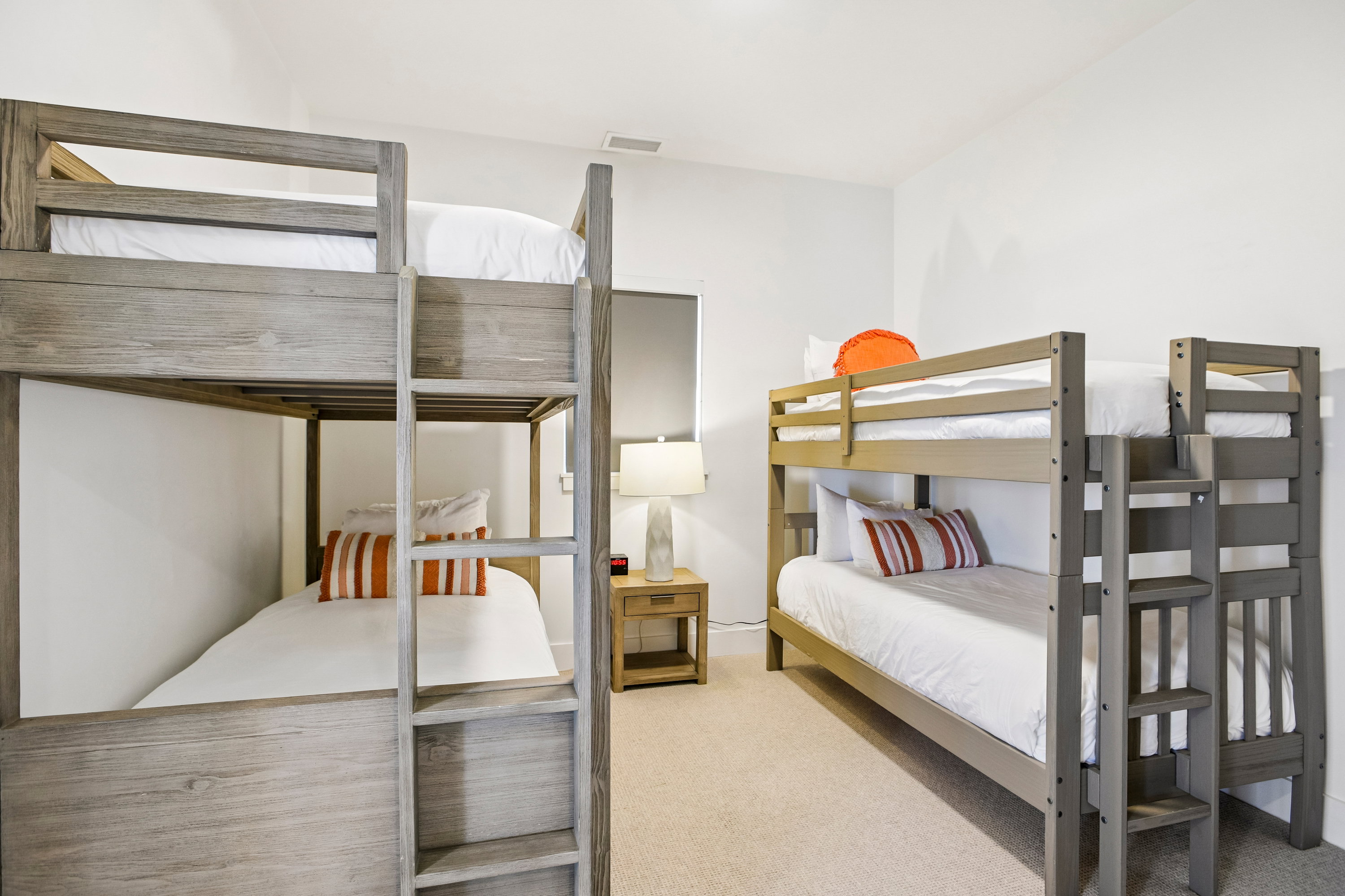 Bedroom featuring two bunk bed frames with wood-finish construction and integrated ladders
