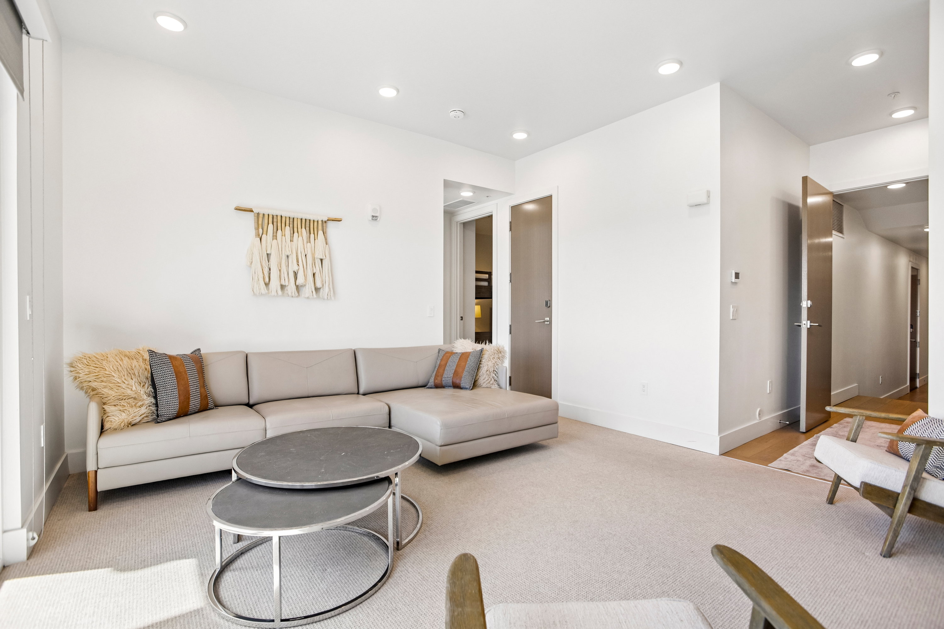 Spacious living area featuring neutral carpeting and recessed lighting