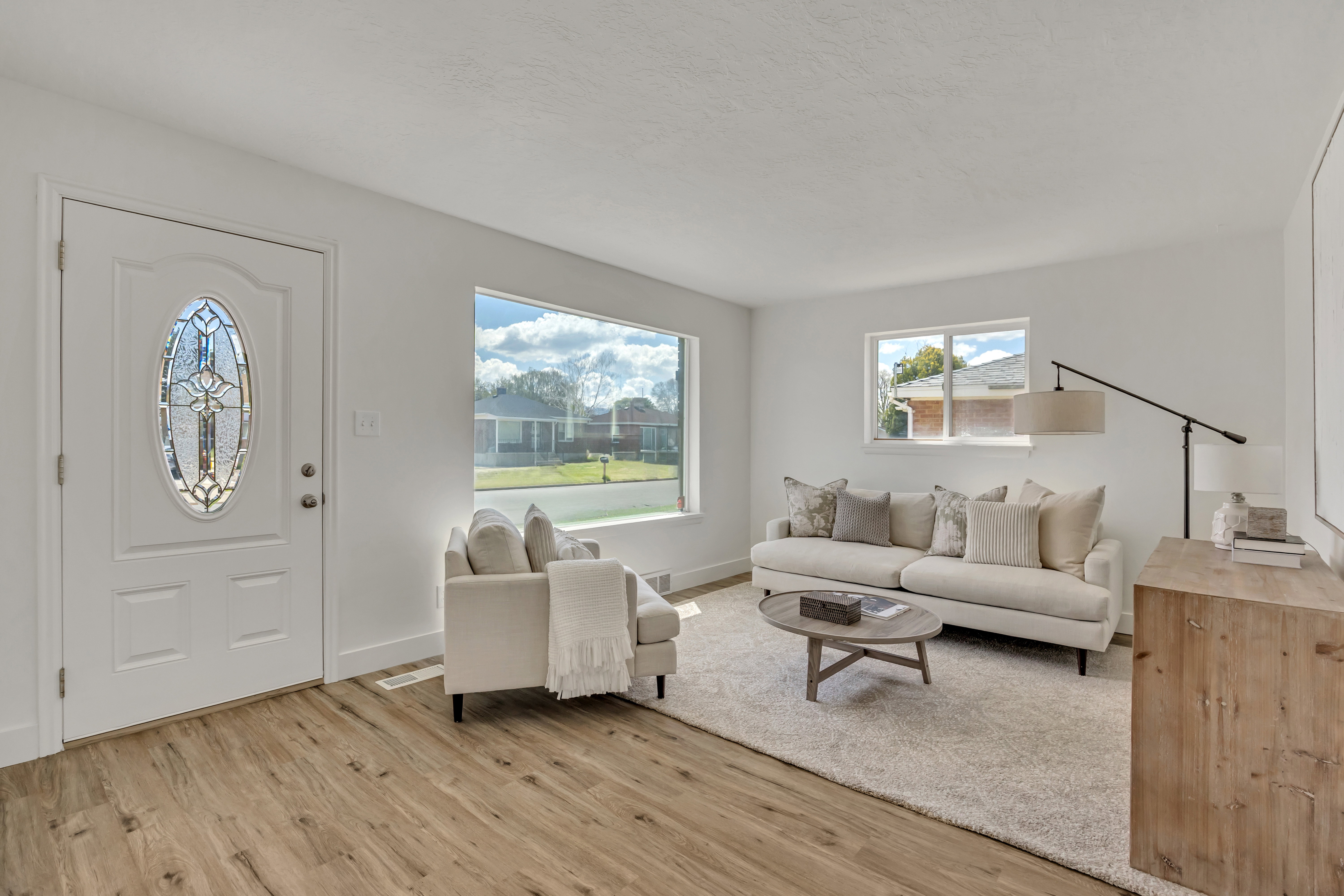Bright living area featuring wood-finish flooring and white walls