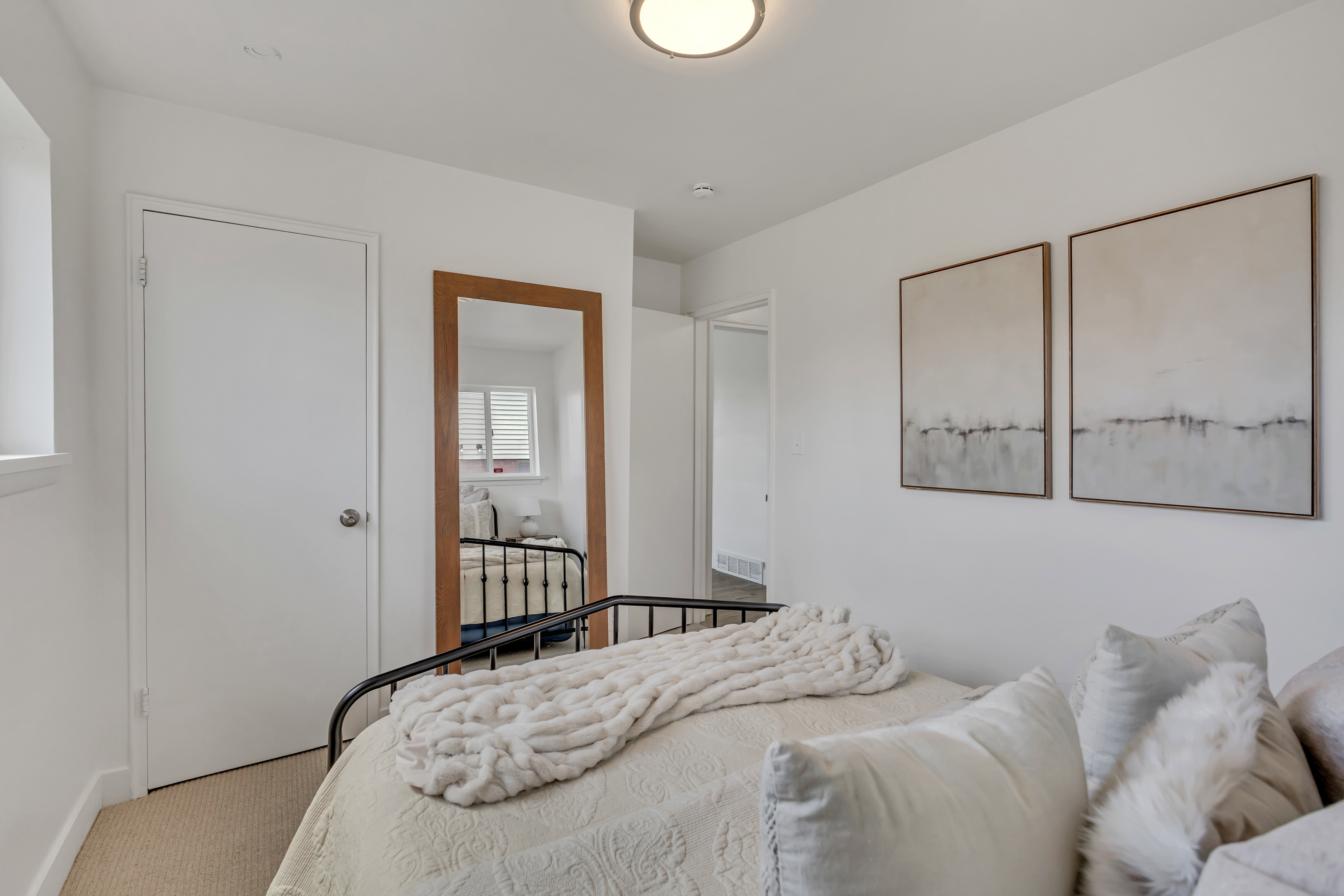 White walls with a flush-mount ceiling light and neutral carpeting