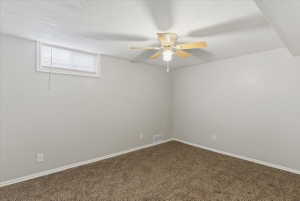 Room featuring neutral tone walls, brown carpeting, and a ceiling fan with light fixture