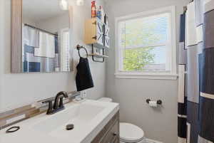 Contemporary bathroom featuring a single white basin, dark bronze faucet, and a mosaic tile backsplash