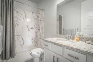 Full bathroom with vanity and a marble finish shower