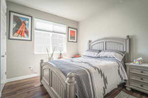 Bedroom featuring dark wood finished floors and baseboards