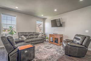 Living area featuring dark wood-type flooring, recessed lighting, and a textured ceiling