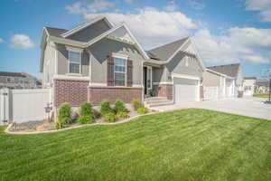Craftsman-style house featuring brick siding, stucco siding, driveway, and a garage