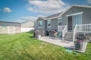 Rear view of house featuring a patio area, stucco siding, and a storage unit