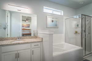 Ensuite bathroom featuring a stall shower, a garden tub, and vanity