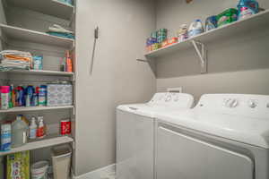 Laundry room featuring washer and dryer and baseboards