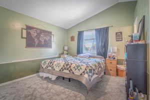 Carpeted room featuring a vaulted ceiling, a window with blinds, and two-tone wall paint