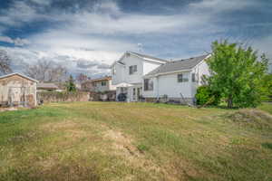 Expansive backyard featuring a large grass area and mature perimeter shrubbery