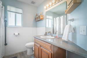Bathroom featuring wood-finish flooring, a vanity with a built-in sink, and a large mirror