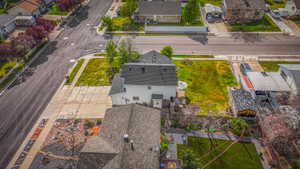 Residential property featuring a dark shingle roof, a paved driveway, and an expansive grassy lot