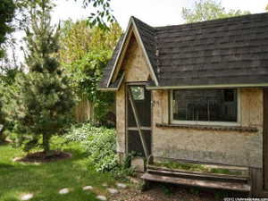 Exterior structure featuring an asphalt shingle roof, a gabled entry, and a side window