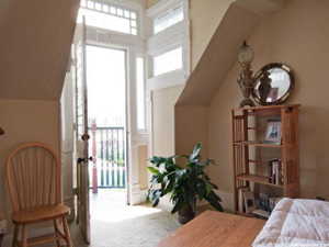 Entryway with transom window and sidelights, featuring a white painted door opening to a balcony with decorative railing