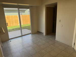 Sliding glass door opening to a concrete patio and fenced yard