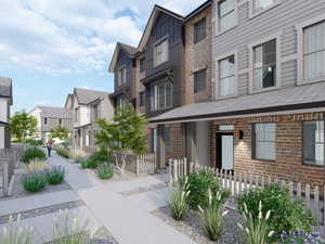 Contemporary multi-level townhome featuring a mix of brick and siding exteriors