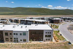 Modern multi-story building featuring stone veneer and wood-finish paneling facades, flat roofline, and multiple window configurations