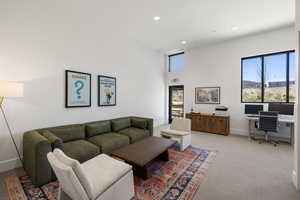 Spacious room with high ceilings, recessed lighting, and large windows