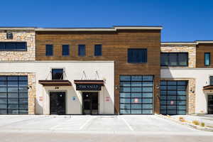 Modern commercial facade featuring a mix of stone veneer, wood paneling, and stucco finishes
