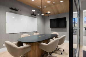 Contemporary meeting space featuring a wood-finish vaulted ceiling and light wood-finish flooring
