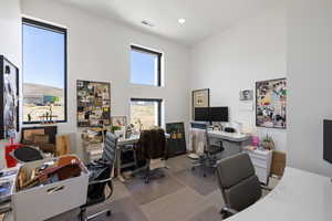 Contemporary interior space featuring high ceilings and multiple large windows
