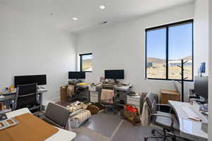 High ceilings and recessed lighting illuminate this bright space, featuring multiple large windows with black frames