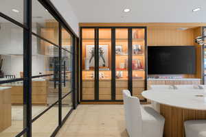 Steel-framed glass panels delineate the space, complementing light wood-finish flooring