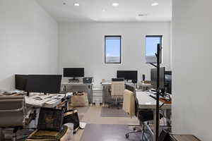 Office space featuring recessed lighting, a neutral color palette, and two windows with black trim